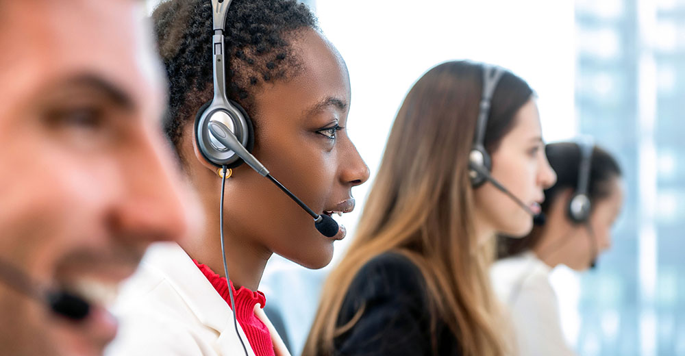 Photo of people answering telephone calls on headsets