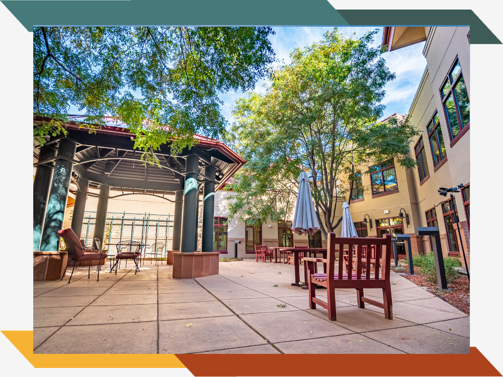 An outdoor patio with trees, a gazebo, and benches.