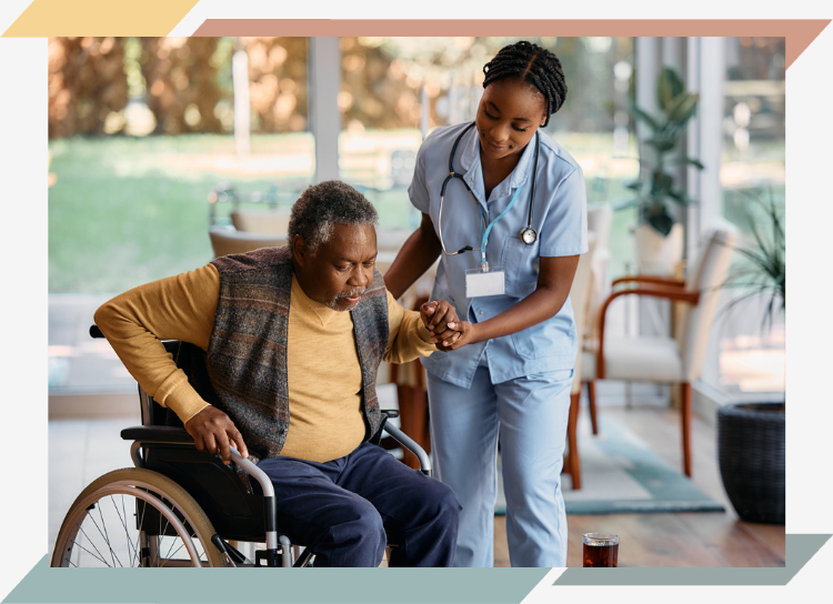 A nurse helping an older man get out of his wheelchair