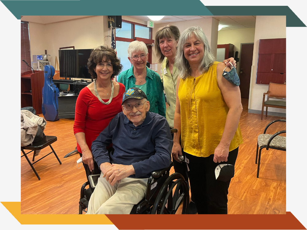 Several staff members and a resident smiling together in a common room.