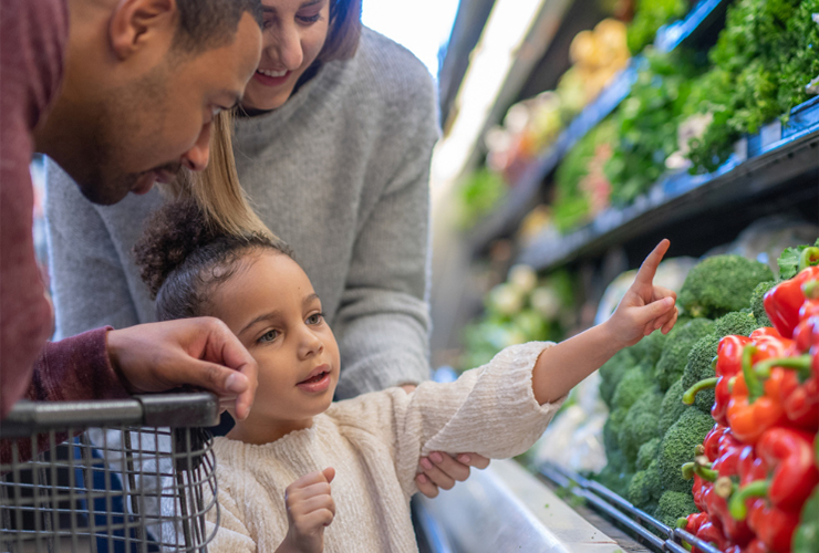 Young girl reaching for vegetables