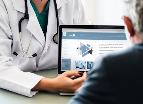 Medical professional showing a patient a computer screen