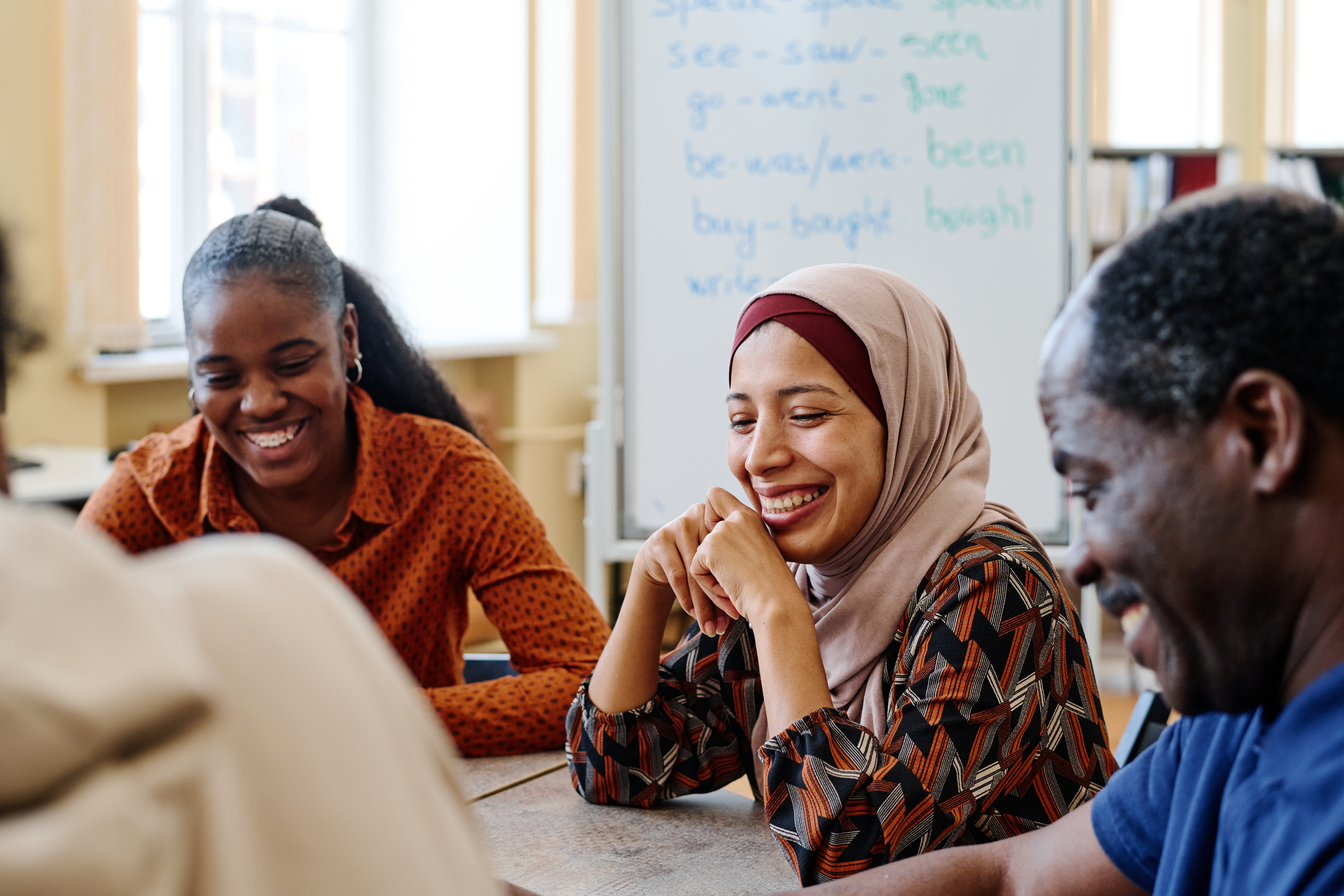 Three people smiling around a table