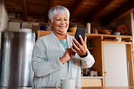 Woman looking at phone in kitchen